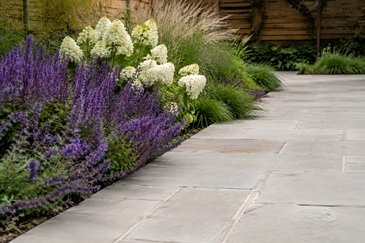 Natural stone garden path bordered by flowering plants